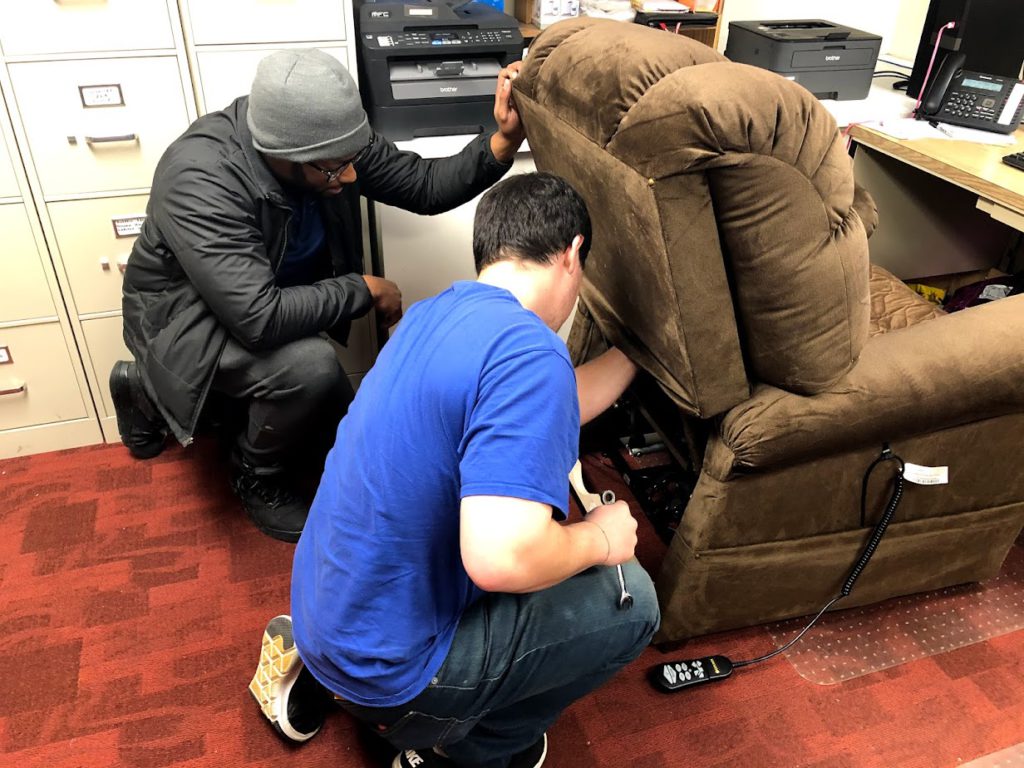 Lift Chair Repair image. Photo of two Oswald's employees fixing a broken lift chair.